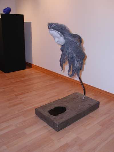 Plaster and cement cast, steel wool, steel bar, black ink.